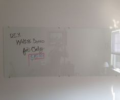 a whiteboard with writing written on it in an office space next to a window