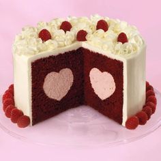 a red velvet cake with white frosting and hearts on the inside is cut in half