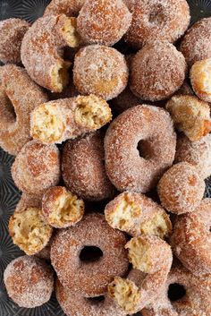 a pile of powdered donuts sitting on top of a glass plate