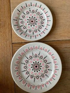 two white plates with pink and black designs on them