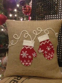 a pillow with two mittens on it sitting next to a christmas ornament