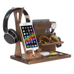 an iphone and headphones are in a wooden holder with ear phones on top of it