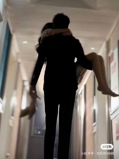 a man and woman are walking down the hallway