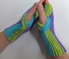 a person is holding their hands together with knitted gloves