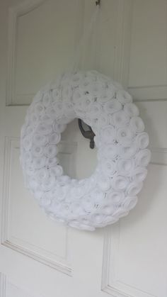 a white wreath hanging on the front door