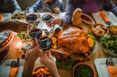 people toasting wine glasses at a thanksgiving dinner