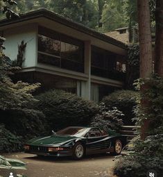 a black car parked in front of a large house surrounded by trees and shrubbery