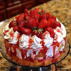 a cake with strawberries on top sitting on a table next to a countertop