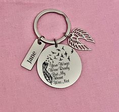 a metal keychain with a quote on the front and an angel charm on the back