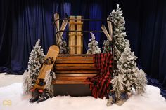 a wooden bench sitting in the snow with skis on it's back end