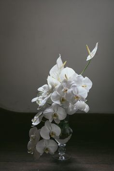 white flowers in a glass vase on a table