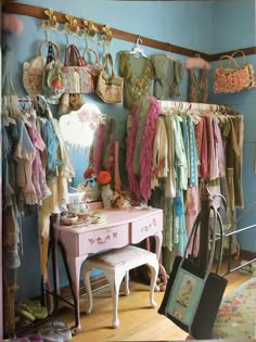 a pink dresser sitting in front of a mirror with lots of clothes hanging on it