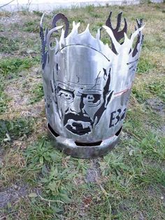 a metal trash can with an image of a man's face painted on it