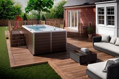 a hot tub sitting on top of a wooden deck next to a white couch and chair