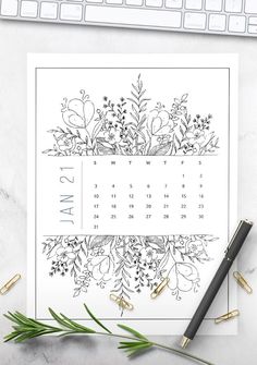 a calendar with flowers and plants on it next to a keyboard, pencil and pen