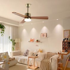 a living room filled with furniture and a ceiling fan in the middle of it's wall