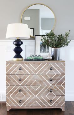 a dresser with a mirror and lamp on top