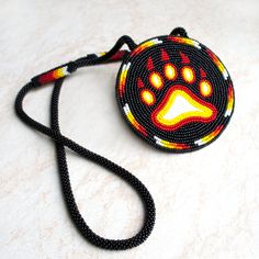 a beaded bag with a dog's paw on it and a lanyard