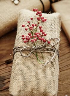 a present wrapped in burlock and tied with twine on top of a wooden table