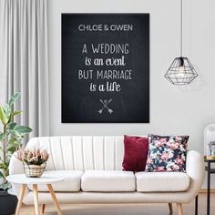 a living room with white furniture and a chalkboard on the wall that says, wedding is an actual but marriage is a life