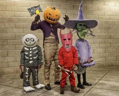 three children in halloween costumes standing next to each other