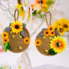 two sunflowers are hanging from twine baskets on a tree with flowers in the background