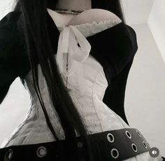 a woman with long black hair wearing a white and black corset, collared shirt and belt