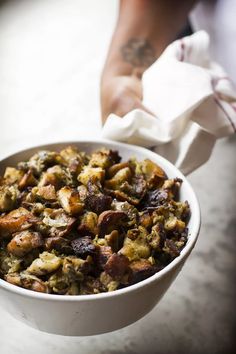 a white bowl filled with food sitting on top of a table next to a napkin