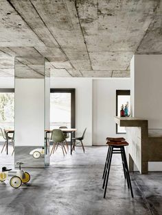 an empty room with mirrors and stools in front of the counter top, as well as other furniture