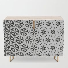 a cabinet with black and white designs on the front, two doors and one drawer