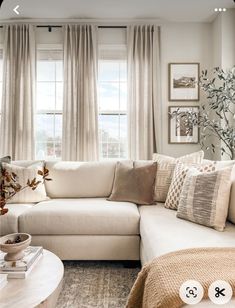 a living room filled with lots of furniture and pillows on top of a white couch