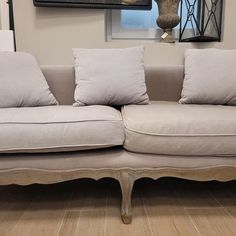 a white couch sitting on top of a hard wood floor