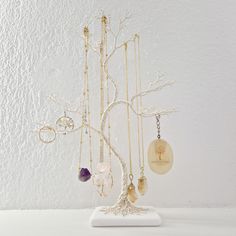 a white tree with several necklaces hanging from it's branches