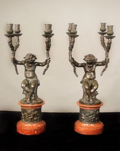 two silver candlesticks sitting on top of each other