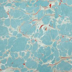 an abstract marble pattern with red and white streaks on blue water, as seen from above