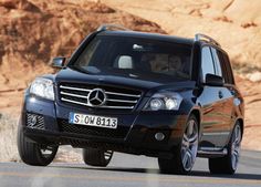 a black mercedes suv driving down the road