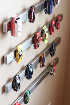 there are many toy cars on the pegs attached to the wall behind the door