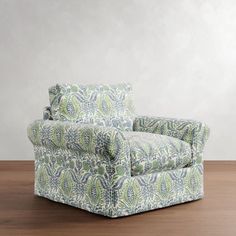 an upholstered chair sitting on top of a wooden floor