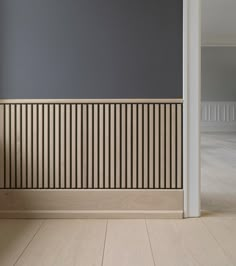 an empty room with wood paneling on the wall and wooden floor in front of it