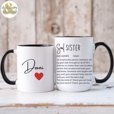 two black and white coffee mugs sitting on top of a wooden table next to each other