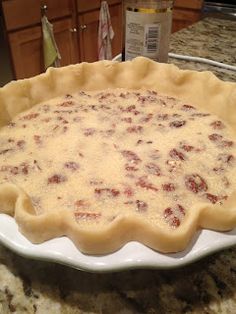 an uncooked pie crust sitting on top of a white plate in the kitchen