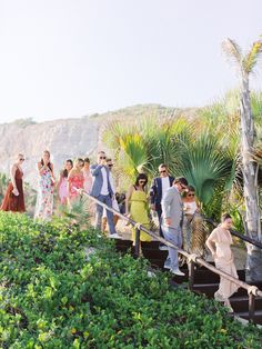 a group of people standing on top of a set of stairs next to trees and bushes