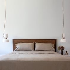 a bed with two lamps hanging above it