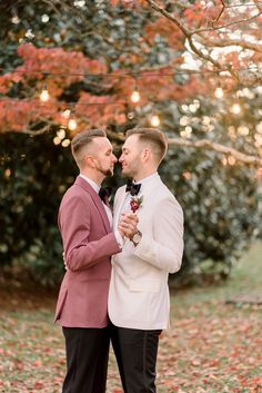 two men in tuxedos standing next to each other and looking at each other