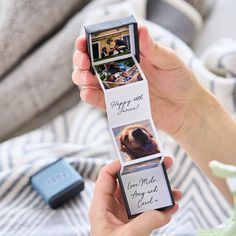 a person holding an open photo book with pictures on it and two photos attached to the cover