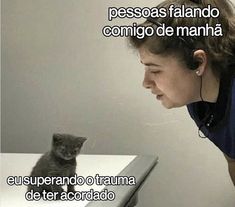 a woman is looking at a kitten on a table with the caption in spanish