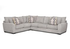 a gray sectional couch with pillows on it's back and side facing each other