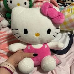 a hello kitty stuffed animal sitting on top of a bed