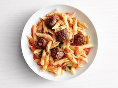 a white plate topped with pasta and meatballs