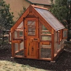 a small wooden house made out of wood and wire with windows on the front door